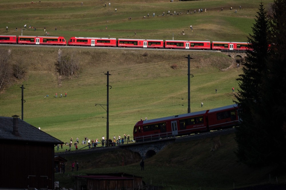 South of Bergün where the leading car is seen descending the steep gradient to the town's railway station whilst the rest of its train is yet to traverse the spiral tunnels before this point.