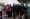 A group of passengers wait for the bus at a bus stop in Beijing on March 13, 2023.