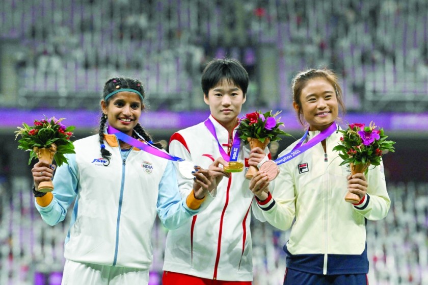 (Left) Women's long jump silver medalist Ansi Sojan Edapili of India, gold medalist Xiong Shiqi of China and bronze medalist Yue Yayan of Hong Kong celebrate on the podium. —AFP