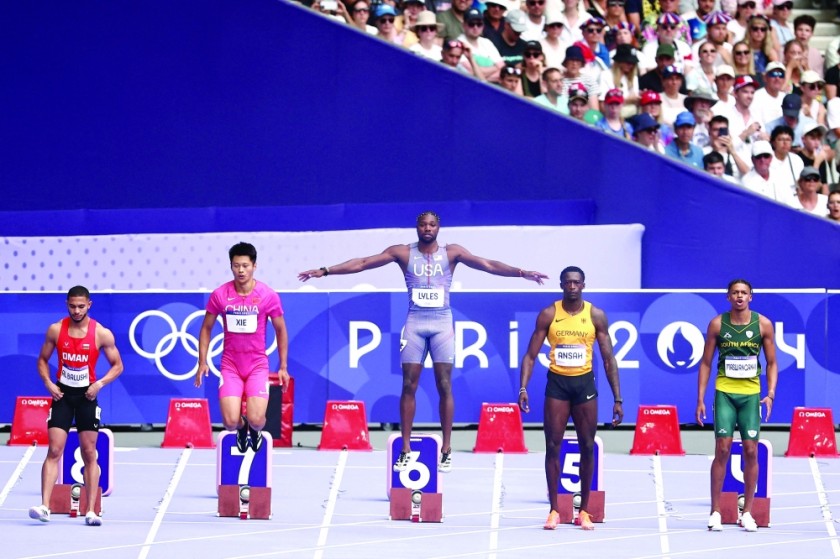 Oman's Ali Anwar Ali Al-Baroohi, China's Xie Zhenye, the United States' Noah Lyles, Germany's Erwin Ansah and South Africa's Sean Maswangani prepare to start during the men's 100m preliminary race in athletics at the 2024 Paris Olympics at the Stade de France in Saint-Denis, north of Paris. -