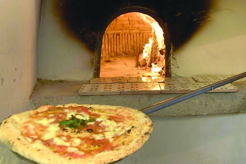 A pizza maker prepares a Pizza Margherita. — AFP