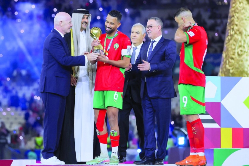 رئيس FIFA جياني إنفانتينو (يسار) وأمير قطر الشيخ تميم بن حمد آل ثاني (الثاني من اليسار) يقدمان الكأس للاعب خط الوسط المغربي رقم 6 محمد ربيع هريمات والمهاجم المغربي رقم 9 عبد الرزاق حامد الله بعد فوز فريقهم في المباراة النهائية لكأس العرب 2025 لكرة القدم بين الأردن والمغرب على ملعب لوسيل في لوسيل في 18 ديسمبر 2025. (تصوير كريم جعفر / أ ف ب)