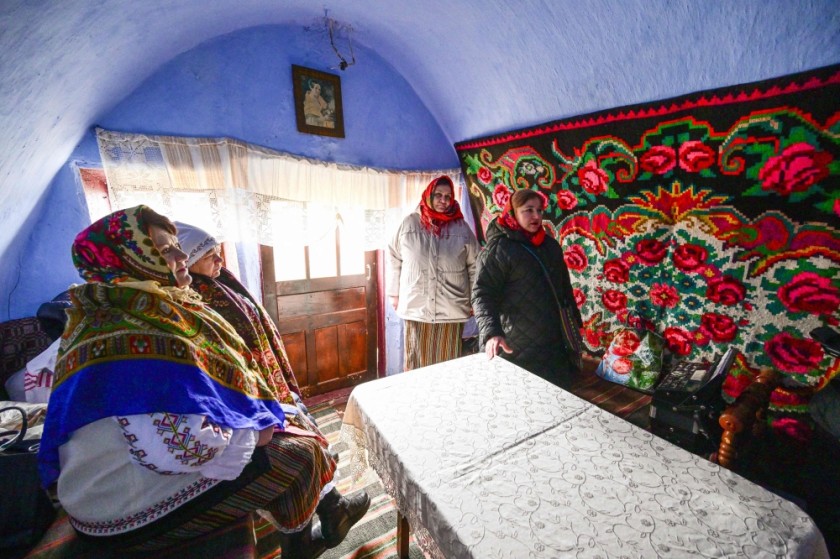 Local women wearing traditional Moldovan clothes gather inside a "basca" museum-house in Rogojeni village.